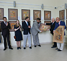 Президент АНИ вручает подарок директору музея -листы реконструированных народных картинок XVII-XIX вв.